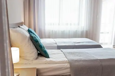 two beds with pillows in a room with a window at Janda Resort & Conference in Mszana Dolna