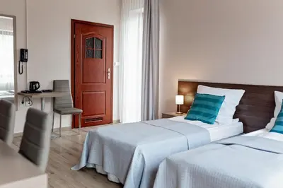 a hotel room with two beds with blue pillows at Janda Resort & Conference in Mszana Dolna