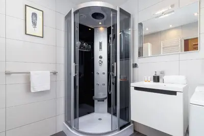 a white bathroom with a shower and a sink at Retro Family Apartment Mały Płaszów by Noclegi Renters in Kraków