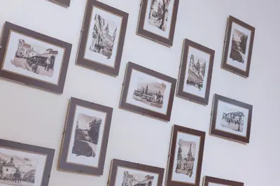 a wall of framed pictures on a white wall at Retro Family Apartment Mały Płaszów by Noclegi Renters in Kraków