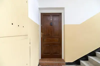 a wooden door in a hallway with stairs at Retro Family Apartment Mały Płaszów by Noclegi Renters in Kraków