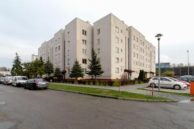 a parking lot with cars parked in front of buildings at Retro Family Apartment Mały Płaszów by Noclegi Renters in Kraków