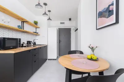 a small kitchen with a wooden table and chairs at Apartments Kraków Czarnowiejska by Noclegi Renters in Kraków