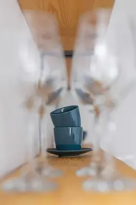 a blue cup sitting on a table with two glasses at Apartments Kraków Czarnowiejska by Noclegi Renters in Kraków