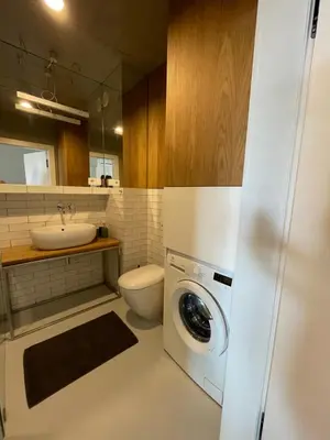a bathroom with a washing machine and a sink at By The River in Kraków