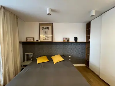 a bedroom with a bed with two yellow pillows at By The River in Kraków