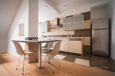 a kitchen with a table and chairs and a refrigerator at Apartament Best Rest in Wadowice