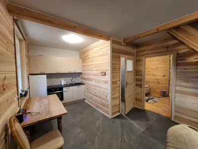 a kitchen with wooden walls and a wooden table at Agro-Gala in Rabka