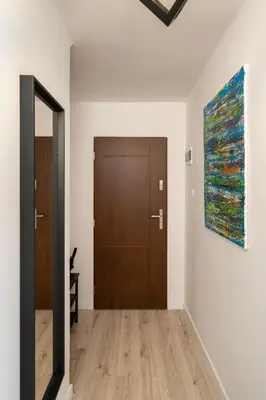 a hallway with a door and a painting on the wall at Staymoovers - Ladne mieszkanie w poblizu Energylandii - Parking in Zator