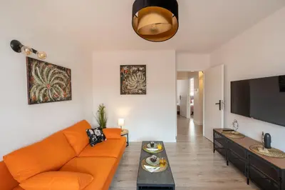 a living room with an orange couch and a flat screen tv at Staymoovers - Ladne mieszkanie w poblizu Energylandii - Parking in Zator