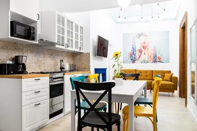 a kitchen and dining room with a table and chairs at Magnificent Apartments Zyblikiewicza 11a, central location in Kraków