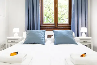 a white bed with two pillows and a window at Magnificent Apartments Zyblikiewicza 11a, central location in Kraków