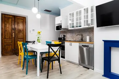 a kitchen with a table and yellow chairs in a room at Magnificent Apartments Zyblikiewicza 11a, central location in Kraków