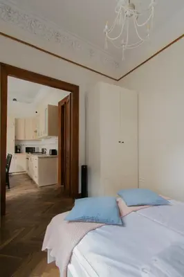 a bedroom with a large white bed with a chandelier at Magnificent Apartments Zyblikiewicza 11a, central location in Kraków