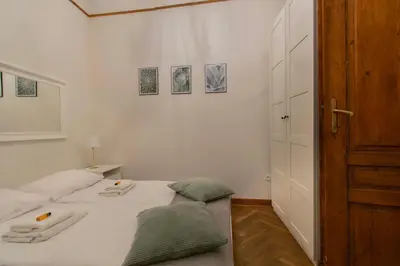 a bedroom with a white bed with two pillows on it at Magnificent Apartments Zyblikiewicza 11a, central location in Kraków