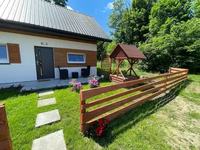 a fence in front of a house with a gazebo at Domek całoroczny Zagroda MłyńSKI in Sułkowice