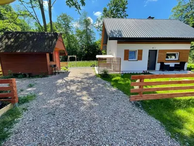 a small cabin with a fence next to it at Domek całoroczny Zagroda MłyńSKI in Sułkowice