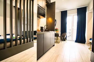 a living room with a kitchen and a bedroom at ApartPark Centrum Zator in Zator