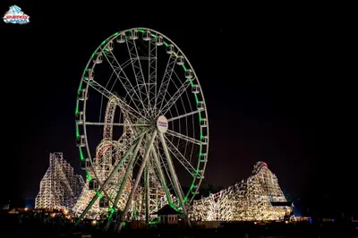 a large ferris wheel with christmas lights at night at ApartPark Centrum Zator in Zator