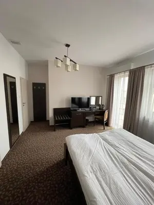a desk with a television and a chair in a room at Apartamenty Centrum in Olkusz