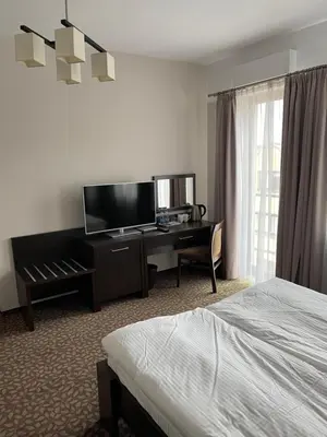 a hotel room with two beds and a chandelier at Apartamenty Centrum in Olkusz