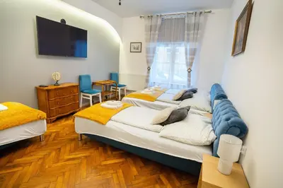 a bedroom with two beds and a tv on the wall at KrakowApart Zyblikiewicza in Kraków