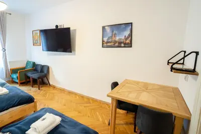 a room with a bed and a table and a tv at KrakowApart Zyblikiewicza in Kraków