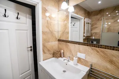 a bathroom with a sink and a mirror at KrakowApart Zyblikiewicza in Kraków