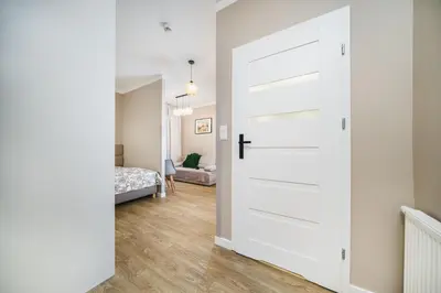 a white door in a room with a bedroom at Apartament A Dietla in Kraków