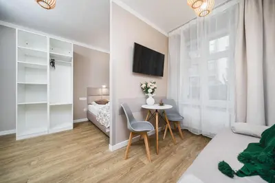 a bedroom with a bed and a table and chairs at Apartament A Dietla in Kraków