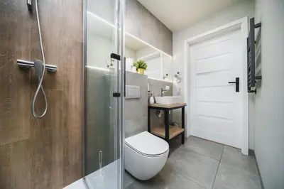 a bathroom with a toilet and a glass shower at Apartament A Dietla in Kraków
