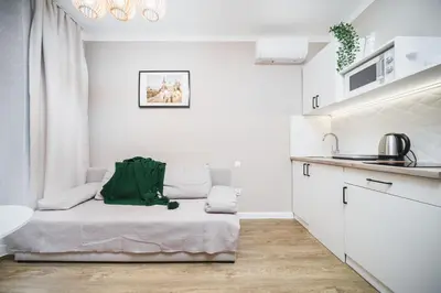 a white kitchen with a couch in a room at Apartament A Dietla in Kraków