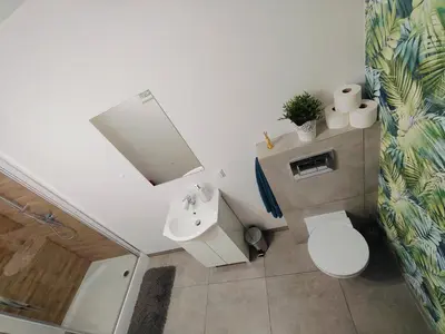 a bathroom with a white toilet and a sink at Apartament Sumik in Zator