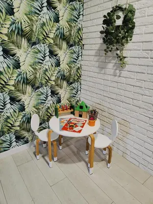 a table and chairs in a room with a wall at Apartament Sumik in Zator