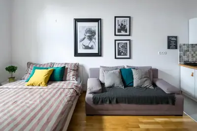 a living room with a couch and a bed at Discover Krakow Apartments - 5 Borowickiej St - Studio next to Opera and Unity Centre in Kraków