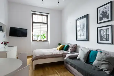a living room with a couch and a window at Discover Krakow Apartments - 5 Borowickiej St - Studio next to Opera and Unity Centre in Kraków