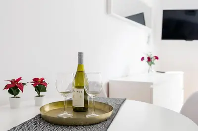 a bottle of wine and two glasses on a table at Discover Krakow Apartments - 5 Borowickiej St - Studio next to Opera and Unity Centre in Kraków