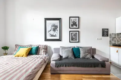a living room with a couch and pictures on the wall at Discover Krakow Apartments - 5 Borowickiej St - Studio next to Opera and Unity Centre in Kraków