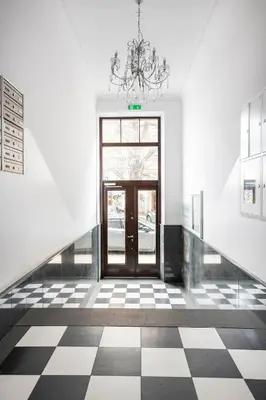 a hallway with a door and a checkered floor at Discover Krakow Apartments - 5 Borowickiej St - Studio next to Opera and Unity Centre in Kraków