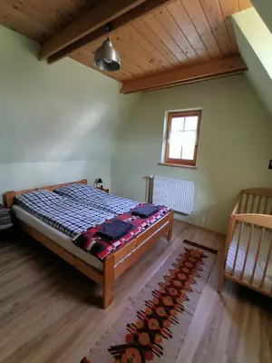 a bedroom with a large bed in a room at Ludwikówka pod Luboniem, stu-letni domek w górach in Naprawa