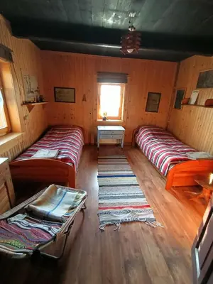 a room with two beds in a room with a window at Ludwikówka pod Luboniem, stu-letni domek w górach in Naprawa