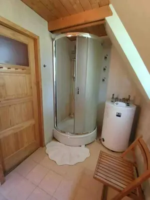 a small bathroom with a shower and a sink at Ludwikówka pod Luboniem, stu-letni domek w górach in Naprawa