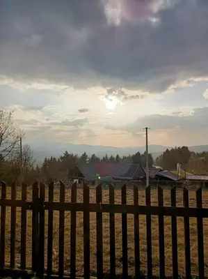 a fence in a field with houses in the background at Ludwikówka pod Luboniem, stu-letni domek w górach in Naprawa