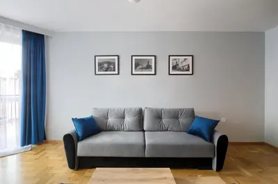 a couch in a living room with blue pillows at Apart-Wita in Wadowice