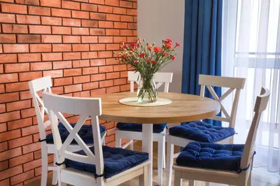 a wooden table with chairs and a vase of flowers on it at Apart-Wita in Wadowice