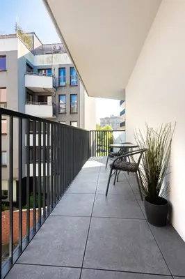 a patio with a table and a bench on a balcony at Mary&Arte Apartments Grzegórzecka 15 in Kraków