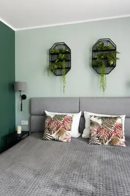 a bedroom with a bed with two bird cages on the wall at Mary&Arte Apartments Grzegórzecka 15 in Kraków