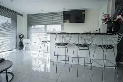 a kitchen with four bar stools and a counter at Willa Pod Zamczyskiem in Podzamcze