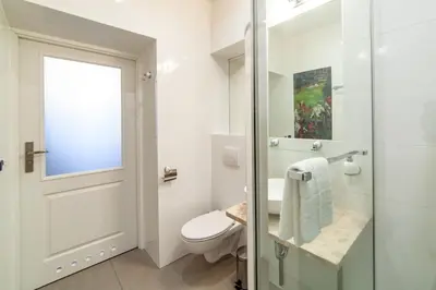a bathroom with a toilet and a glass shower door at MILU Apartments Kurkowa in Kraków