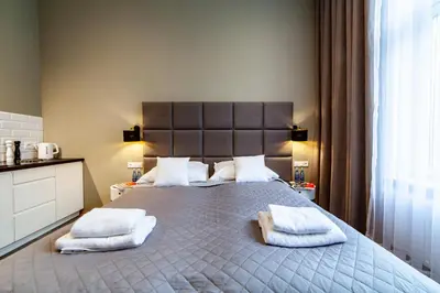 a bedroom with a large bed with towels on it at MILU Apartments Kurkowa in Kraków